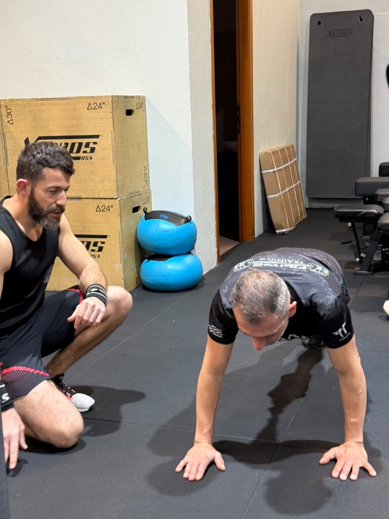 Istruttore di Fierce Training a Cagliari segue un allievo durante un esercizio a corpo libero