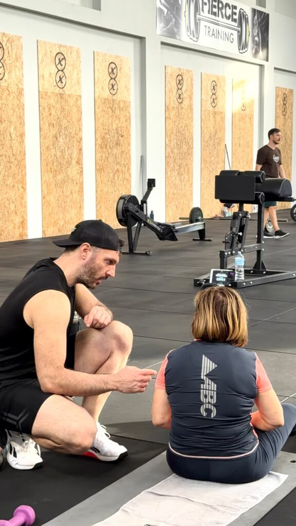 Personal trainer spiega un esercizio a un'allieva da Fierce Training a Cagliari