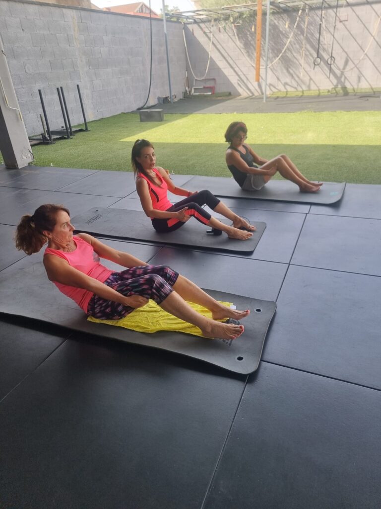 Esercizi di Pilates a corpo libero sul tappetino, affacciati sul prato di Fierce Training a Cagliari